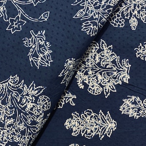 May include: A navy blue fabric with a white floral pattern. The fabric has a subtle dotted texture.