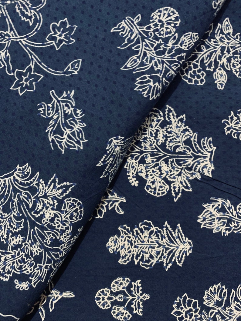 May include: A navy blue fabric with a white floral pattern. The fabric has a subtle dotted texture.