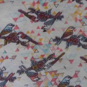 K&ouml;nnte beinhalten: Ein wei&szlig;er Stoff mit einem sich wiederholenden Muster aus bunten V&ouml;geln und geometrischen Formen. Die V&ouml;gel sind blau, gelb und braun mit rosa Bl&uuml;ten. Die geometrischen Formen sind Dreiecke in den Farben Rosa, Blau, Gelb und Grau.