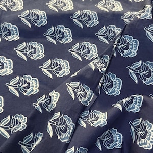 May include: A navy blue fabric with a white floral pattern. The fabric is soft and has a subtle sheen.
