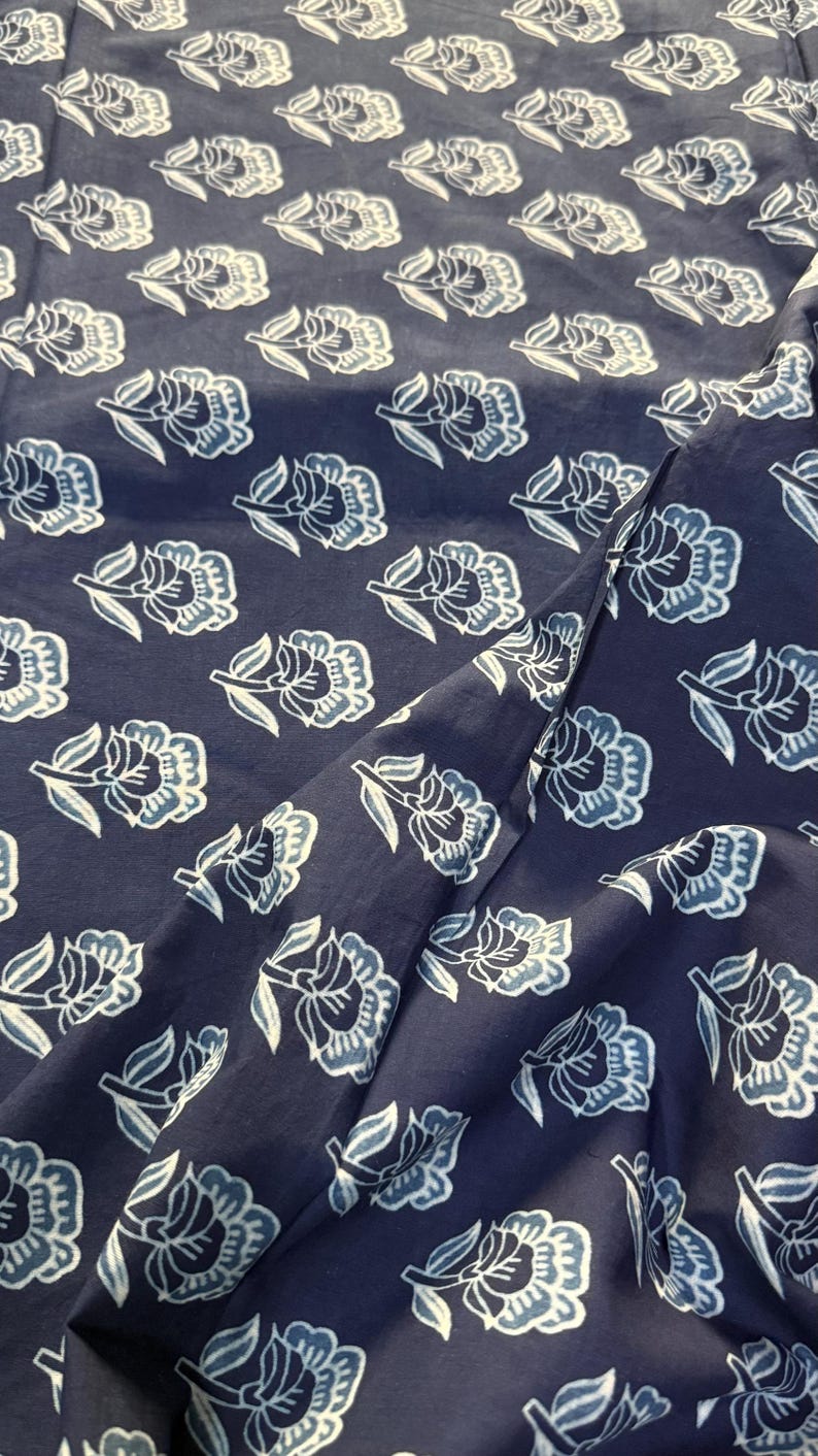 May include: A navy blue fabric with a white floral pattern. The fabric is soft and has a subtle sheen.