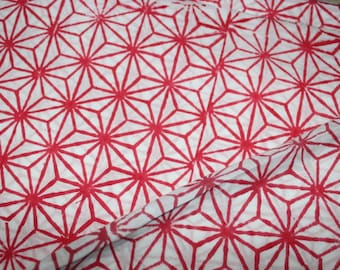 May include: White fabric with a red geometric pattern of repeating star shapes.