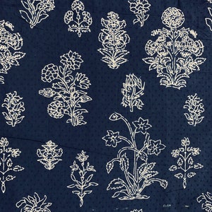May include: A dark blue fabric with a white floral pattern. The pattern features various floral designs, including leaves, stems, and flowers.