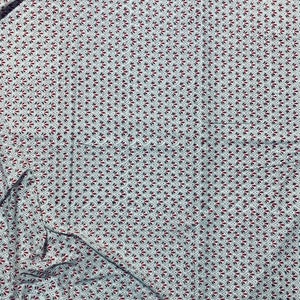 May include: White fabric with a repeating pattern of red and black fan-shaped designs. The fabric is folded, showing the texture and drape of the material. The pattern is evenly spaced across the surface.