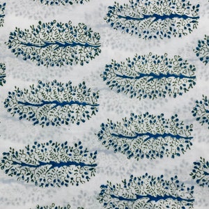 May include: White fabric with a blue and green floral pattern. The pattern is a repeating design of stylized leaves with small dots.
