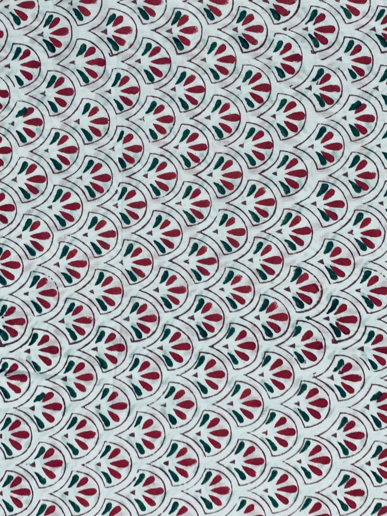 May include: White fabric with a repeating pattern of maroon and dark green stylized leaf shapes. The leaves are arranged in a scalloped design, creating a textured appearance. The fabric is likely used for textiles or home decor.
