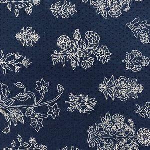 May include: A navy blue fabric with a white floral pattern. The pattern features a variety of flowers and leaves, all in a simple, elegant style.