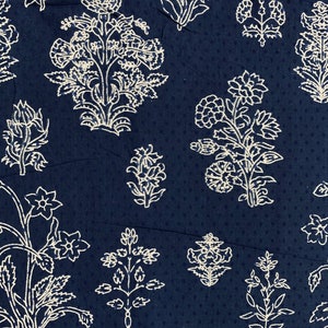 May include: A navy blue fabric with a white floral pattern. The fabric features a repeating design of stylised flowers and leaves.