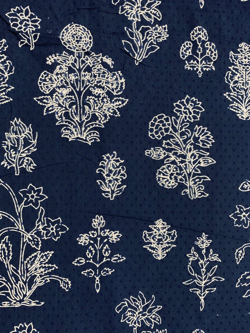 May include: A navy blue fabric with a white floral pattern. The fabric features a repeating design of stylised flowers and leaves.