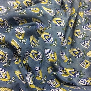 May include: Blue fabric with a repeating pattern of yellow, white, and blue stylized flowers. The fabric has a slightly textured surface.