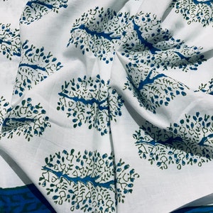 May include: White fabric with a repeating pattern of blue and green stylized trees. The fabric has a blue and green border.