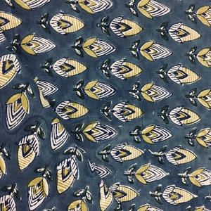 May include: Blue fabric with a repeating pattern of yellow and white stylized flowers. The flowers have a geometric design with white lines and yellow accents.