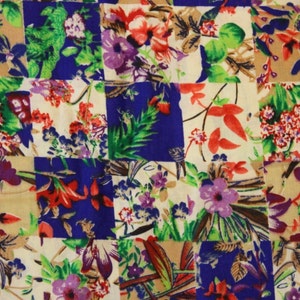 May include: A patchwork fabric featuring a floral design in shades of red, blue, green, and white. The fabric is composed of squares of varying colours and patterns, resulting in a distinctive and visually appealing design.