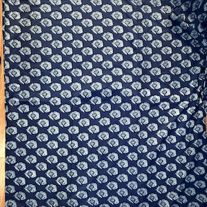 May include: A dark blue fabric with a white floral pattern. The fabric is a repeating pattern of stylized flowers.