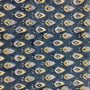 May include: A blue fabric with a repeating pattern of yellow and white stylized flowers. The flowers have a geometric design and are arranged in rows.