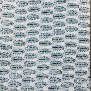 May include: White fabric with a repeating pattern of blue and green stylized tree branches in an oval shape.