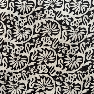May include: Black and white fabric with a repeating floral pattern. The design features stylized flowers and leaves.