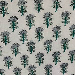 May include: White fabric with a repeating pattern of grey and green floral designs.