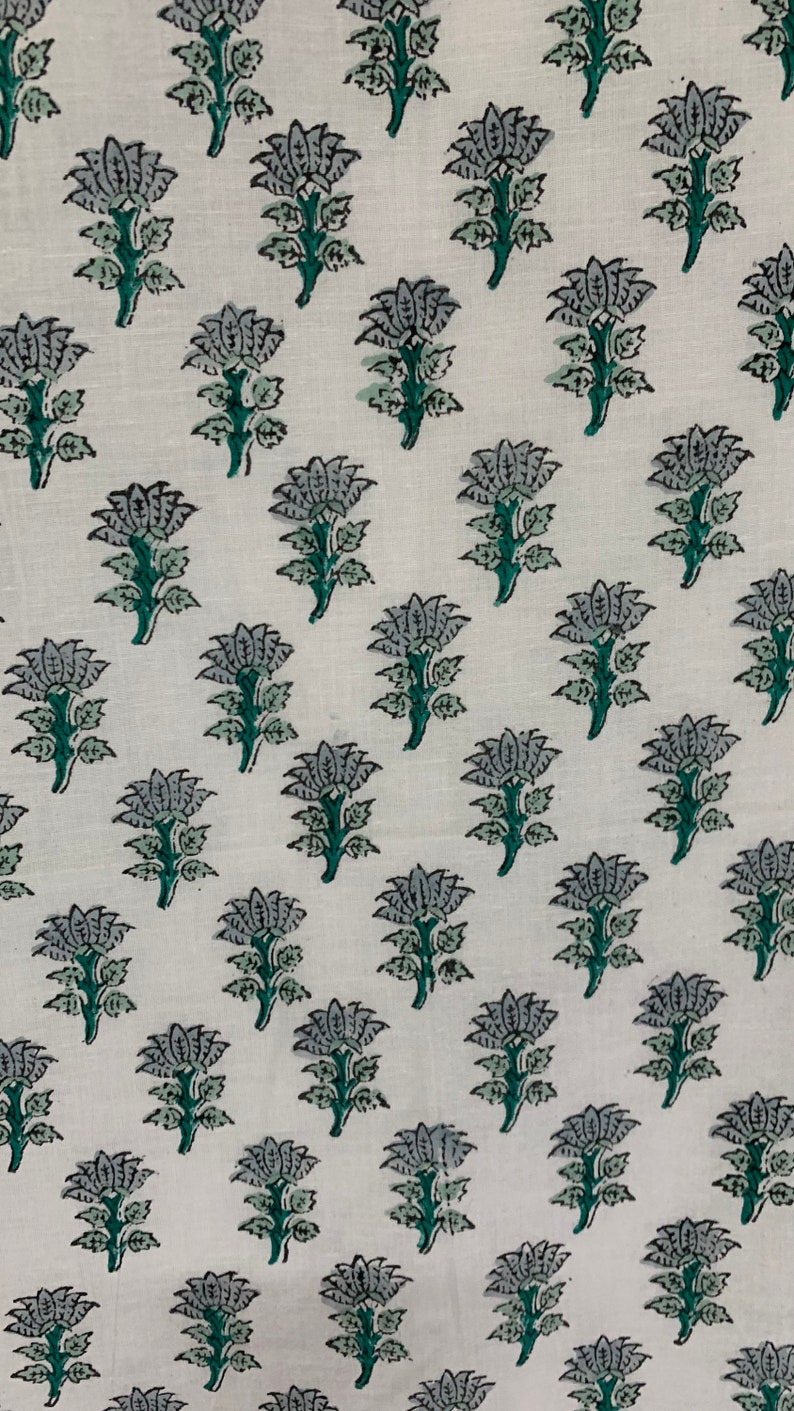 May include: White fabric with a repeating pattern of grey and green floral designs.