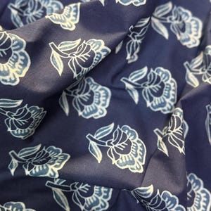 May include: A navy blue fabric with a white floral pattern. The fabric has a soft, textured feel and is perfect for crafting projects.