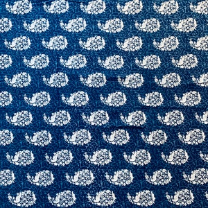 May include: A blue fabric with a white paisley pattern. The fabric has a white border with a repeating leaf design.