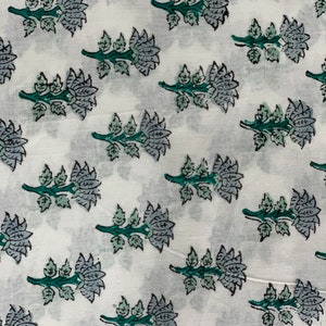 May include: White fabric with a repeating pattern of blue and green floral designs. The flowers are stylised and have a traditional Indian look.
