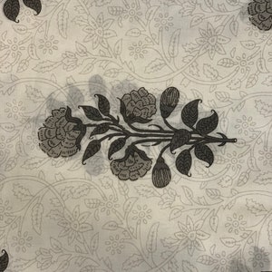 May include: White fabric with a repeating pattern of gray floral designs. The pattern features stylized flowers and leaves.