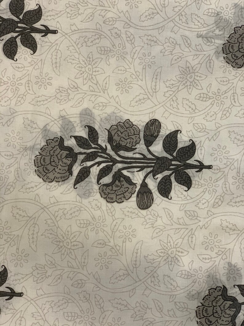 May include: White fabric with a repeating pattern of gray floral designs. The pattern features stylized flowers and leaves.