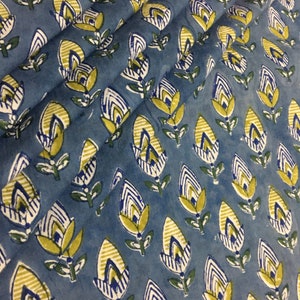 May include: Blue fabric with a repeating pattern of yellow, white, and blue stylized flowers. The fabric has a slightly textured surface.