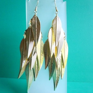 May include: Gold tone dangle earrings with multiple layered leaf shapes.