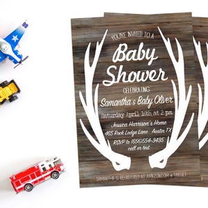 May include: A rustic woodgrain baby shower invitation with white antlers and the text "You're invited to a Baby Shower Celebrating Samantha & Baby Oliver Saturday April 16th at 2 pm Jessica Harrison's Home 465 Rock Ledge Lane Austin TX RSVP to (656)554-3435 call or text Samantha is registered at Amazon.com & Target"