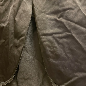 May include: Black skirt with a slit in the back and a scalloped hem.