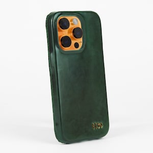 May include: A green leather phone case with a gold camera lens cover and the text "H39" on the back.