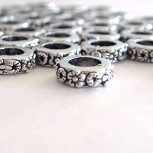 10 Silver Color Metal Large Hole Beads with a design that looks like flowers.