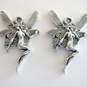 May include: Two silver-toned fairy charms with wings and detailed features. The fairies are in a flying pose with their arms outstretched.