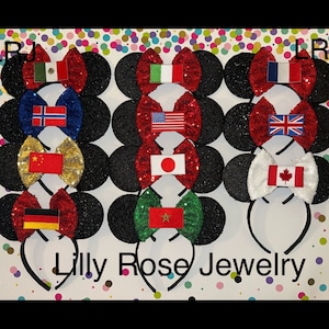 May include: A set of 10 pairs of black sparkly Mickey Mouse ears with different country flags on the bows. The flags include Mexico, Norway, China, Germany, Italy, Japan, Canada, the United Kingdom, the United States, and Vietnam. The ears are on a white background with colorful polka dots. The text "Lilly Rose Jewelry" is printed below the ears.