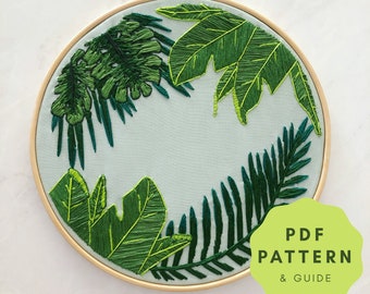 May include: Embroidered hoop art featuring a green leafy design with a white background. The hoop is made of wood and has a light brown finish. The text "PDF PATTERN & GUIDE" is visible in the lower right corner of the image.