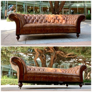 May include: A brown leather Chesterfield sofa with button tufting and wooden legs. The sofa is positioned outdoors on a paved surface.