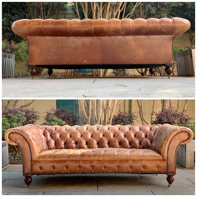 May include: A brown leather sofa with tufted upholstery and rolled arms. The sofa has a classic design and is in good condition.