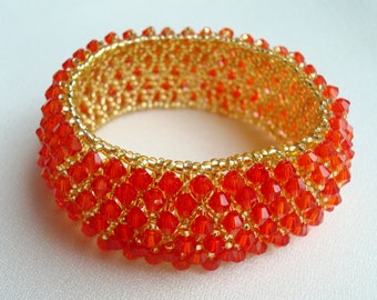 Golden bracelet of beads and red crystals