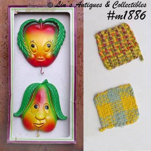 May include: Vintage wall decor set featuring a smiling apple and pear with green leaves, displayed in a box. Includes two woven pot holders in yellow, green, and red patterns. The box has the text "Lin's Antiques & Collectibles #m1886".