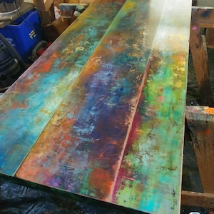May include: A colorful abstract painting on a wooden panel. The painting features a variety of colors, including blue, green, yellow, orange, and red. The painting is signed "David L. Sharp" in the lower right corner.