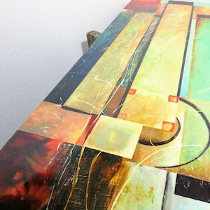 May include: Abstract painting with geometric shapes in shades of brown, yellow, green, and red. The painting has a textured surface and a modern style.