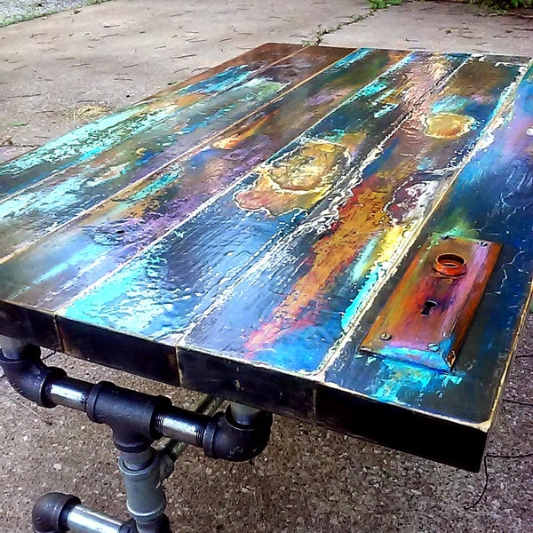 colorfully painted faux bronze weathered patina reclaimed wood coffee table, vintage door pipe leg frame. industrial, art lover gift