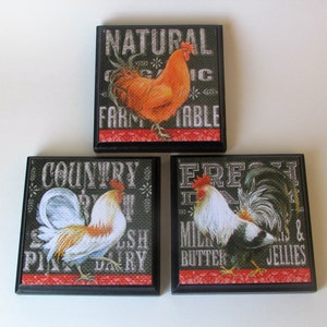 May include: Set of three black framed square signs with rooster illustrations and text. The signs read "Natural Organic Farm Table", "Country Fresh Dairy", and "Fresh Milk Butter Eggs & Jellies".