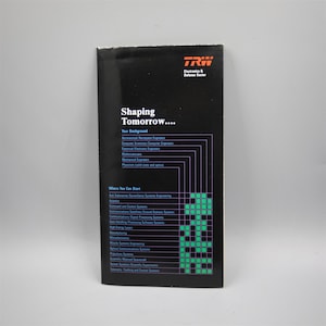 May include: A black and white brochure with the title "Shaping Tomorrow..." and a list of job opportunities at TRW Electronics & Defense Sector. The brochure lists various engineering and scientific fields, including aerospace, computer science, electrical engineering, and physics.