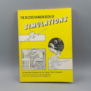 May include: A vintage book titled "THE SECOND RAINBOW BOOK OF SIMULATIONS" with a bright yellow cover. The cover features illustrations of a plane, planets, and figures. Text on the cover indicates it contains 16 programs for the Tandy Color Computer.