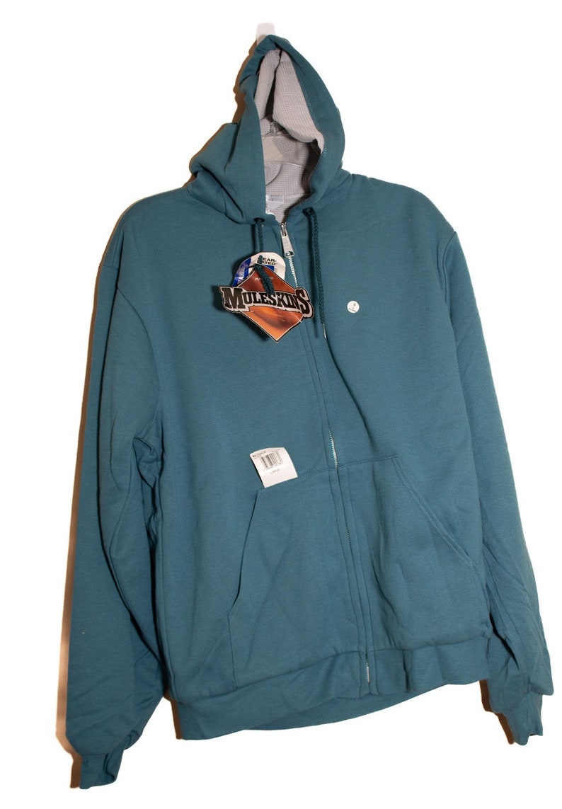 May include: A teal blue zip-up hooded sweatshirt with a white tag that says "MuleSkinner" on it.