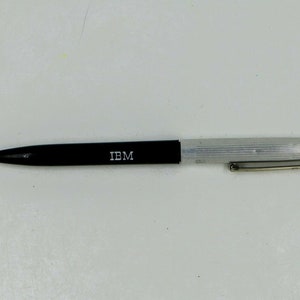 May include: A black and silver pen with the word "IBM" printed on the side.
