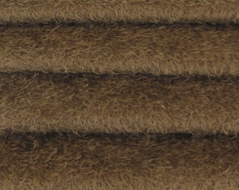 May include: Close-up of a brown fuzzy fabric with a soft, plush texture. The fabric is folded in layers, showcasing its depth and texture.